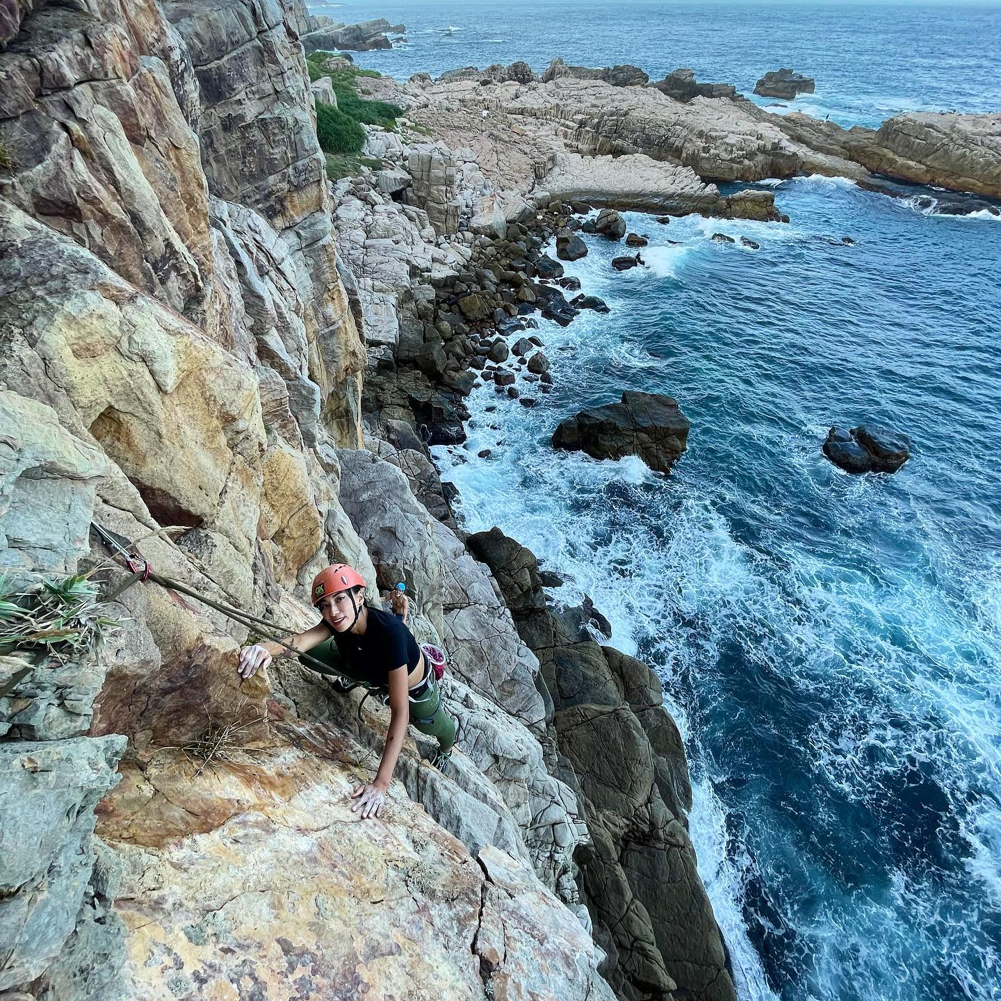 Holding close to the rough sandstone as the jagged spine of Taiwan’s northeast coast bubbles below.