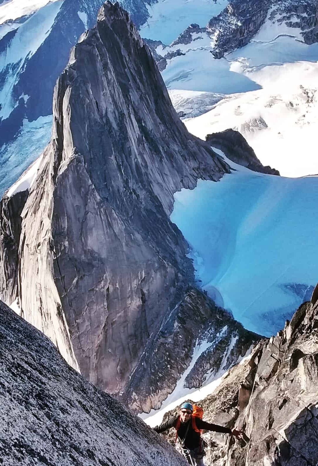 A climber on a slope with the Bugaboo Spire in the background