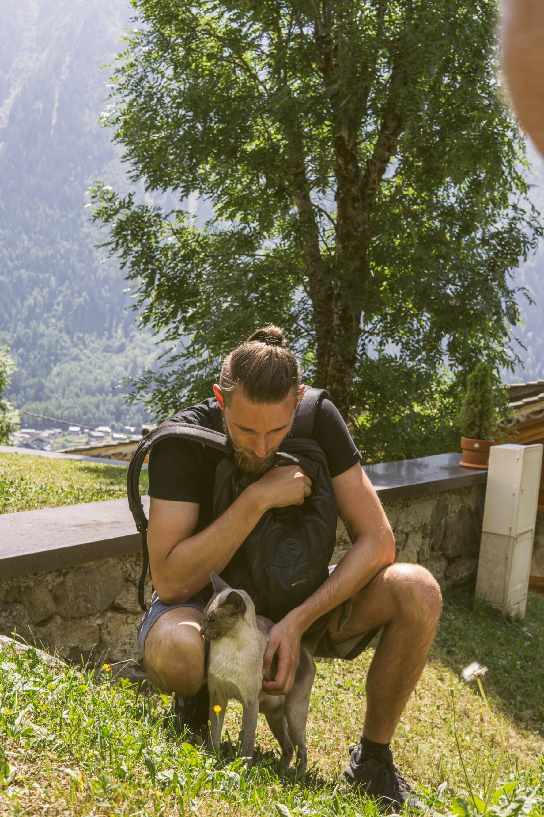 A hiker petting a cat in Chamonix