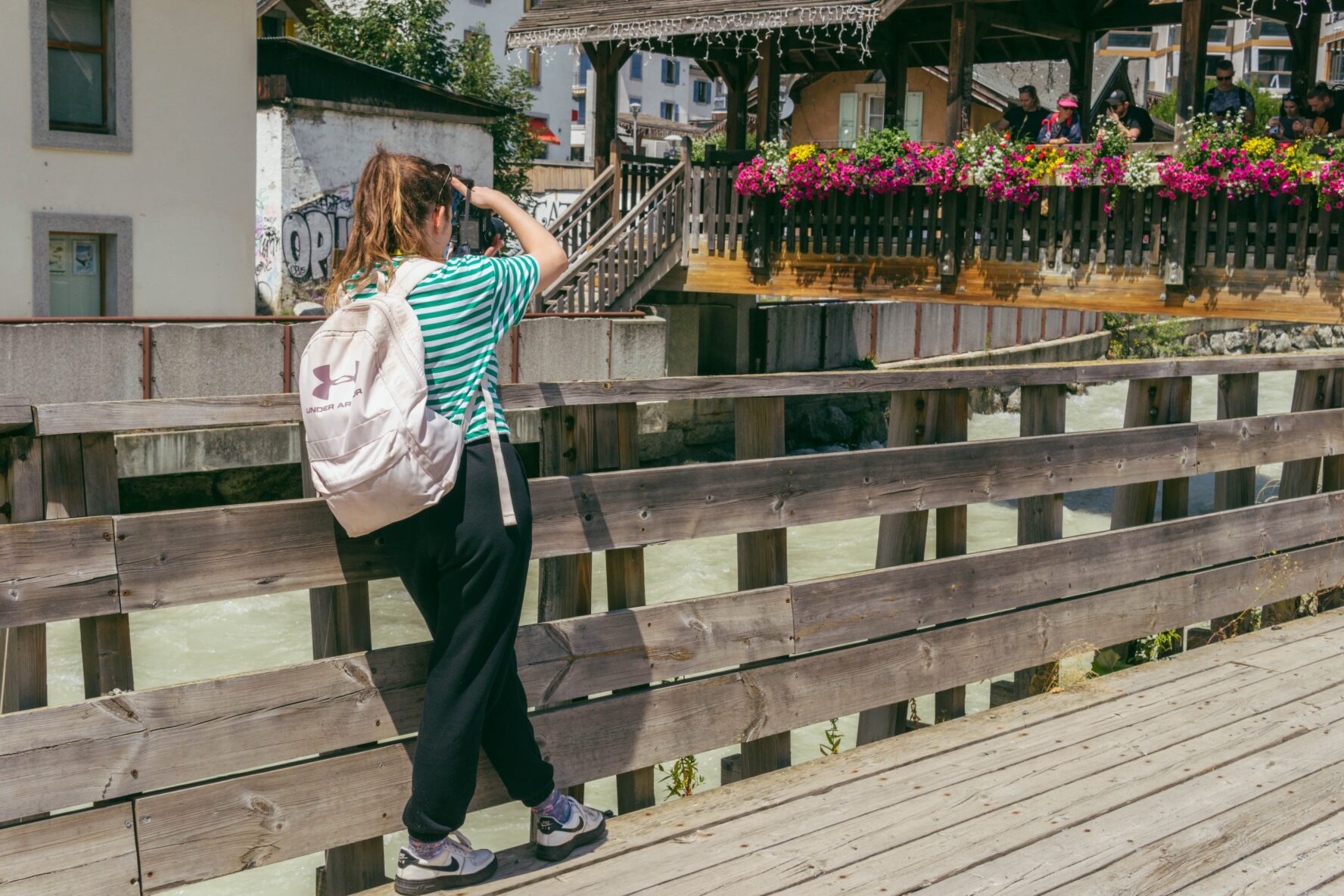 A photographer taking photos of her friends by the Chamonix river.