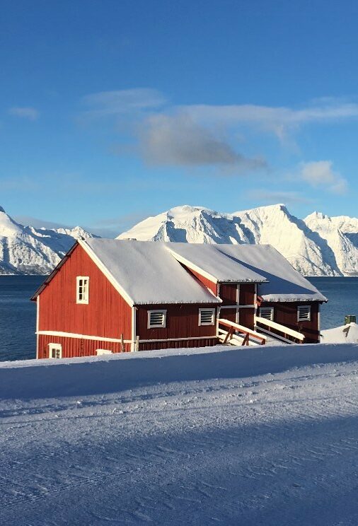 Red houses in the fishermen's villages dotted along coast of the Lyngen Peninsula in Norway.