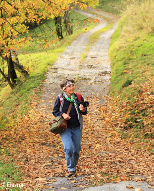 A guide on a photo walk walking across a path with leaves in the Chamonix area