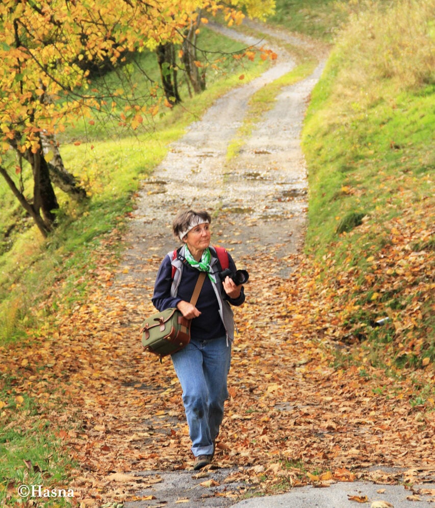 A guide on a photo walk walking across a path with leaves in the Chamonix area