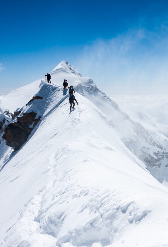 Climbers balancing in blizzard on a narrow ridge of Lyskamm (aka Maneater, 4480 m, Alps)