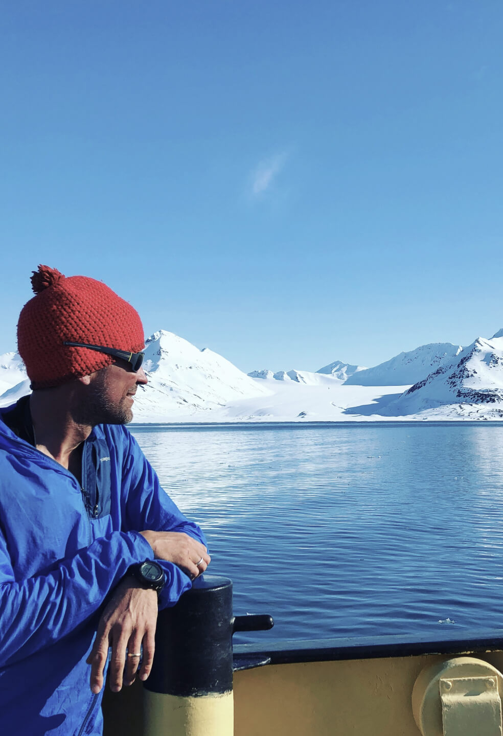 A sailor looking at the Svalbard mountains in the distance.