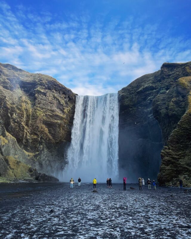 Hikers exploring Skogafoss waterfall in Iceland