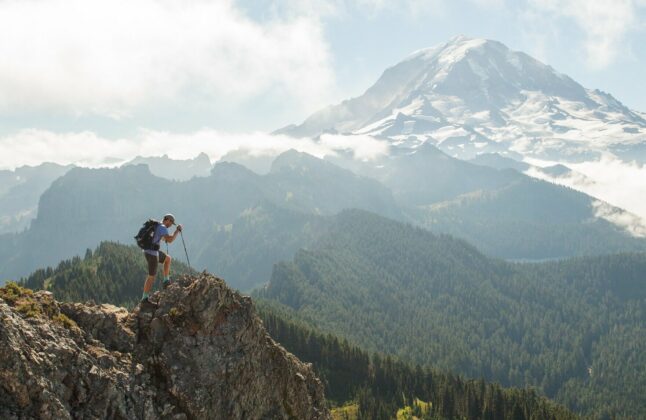 A hiker passes in front of Mount Rainier on one of the many overlook points.