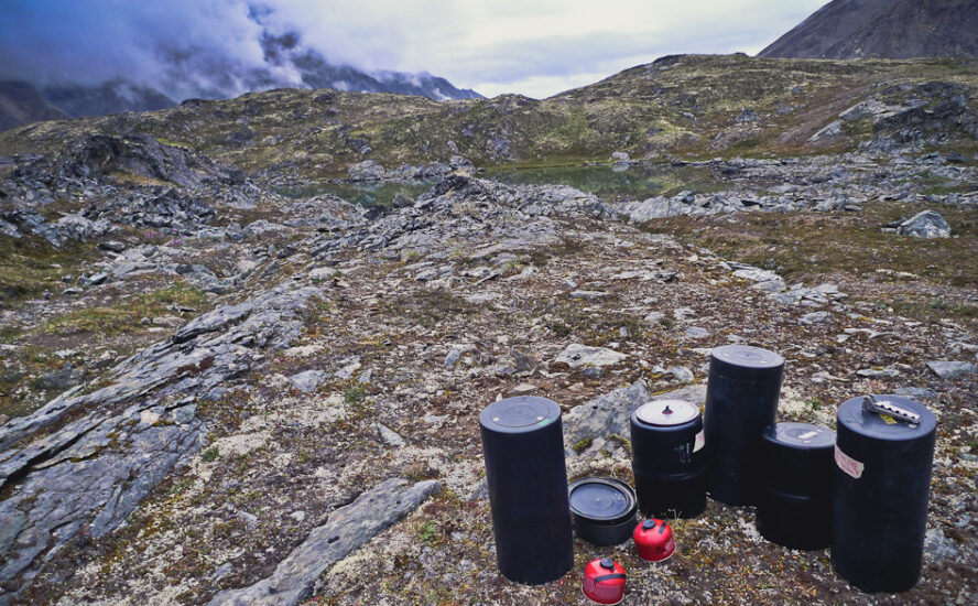 Bear canisters sitting on a rocky outcropping