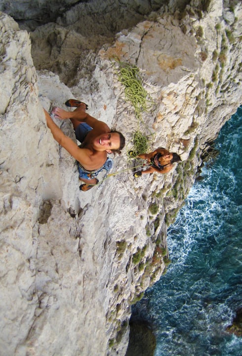 Deep water solo above the stunning blue sea