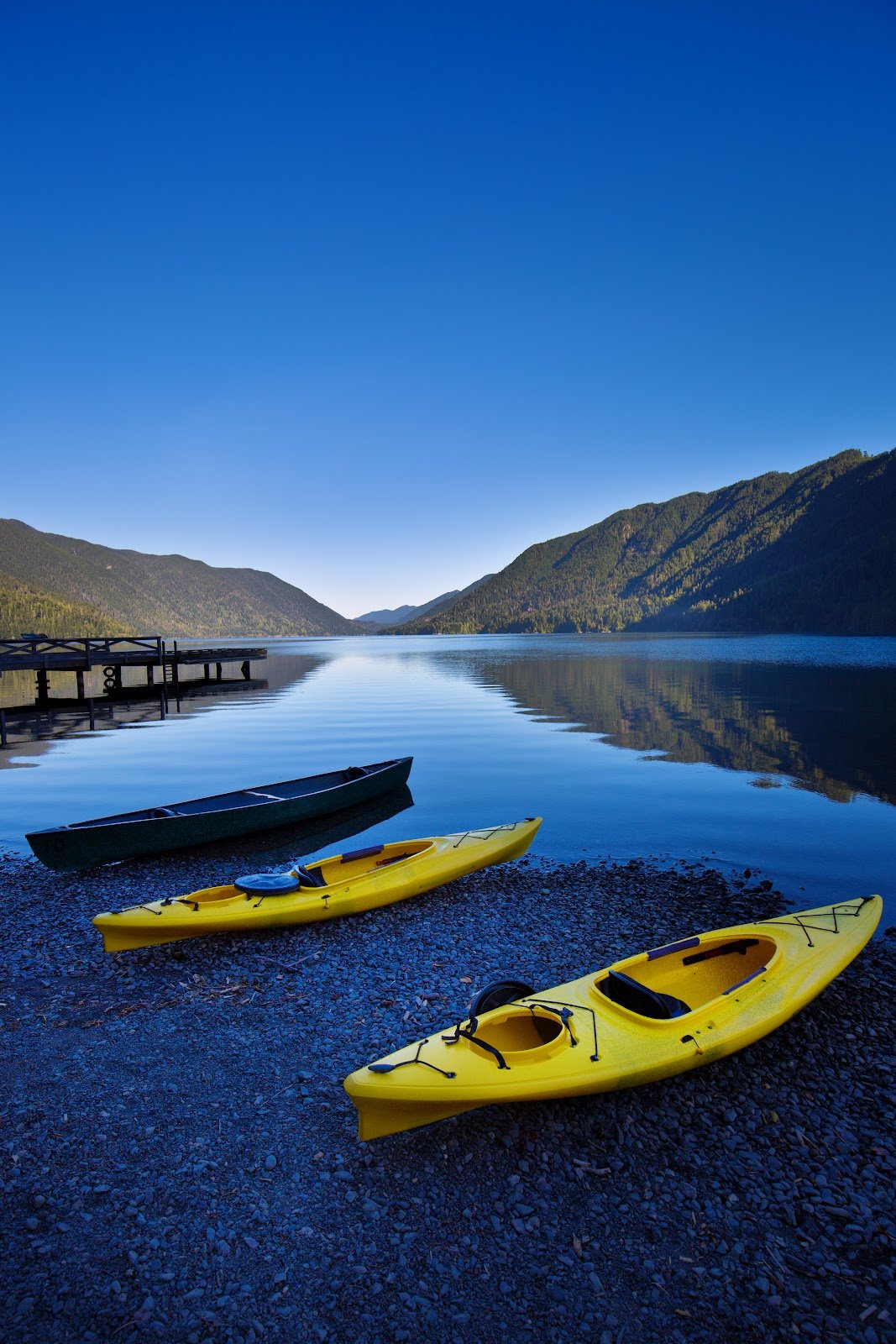 Olympic National Park in Washington State of United States. Water sport of canoes and kayaks at Lake Crescent. The scenic park is located west of the City of Seattle and Tacoma in Washington State. Photographed in vertical format at predawn sunrise.