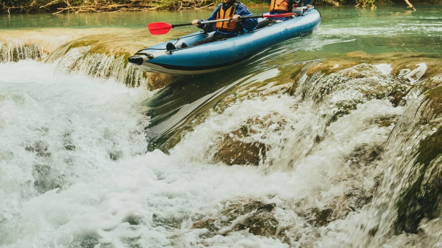 Two people going down a small cascade on river Mrežnica