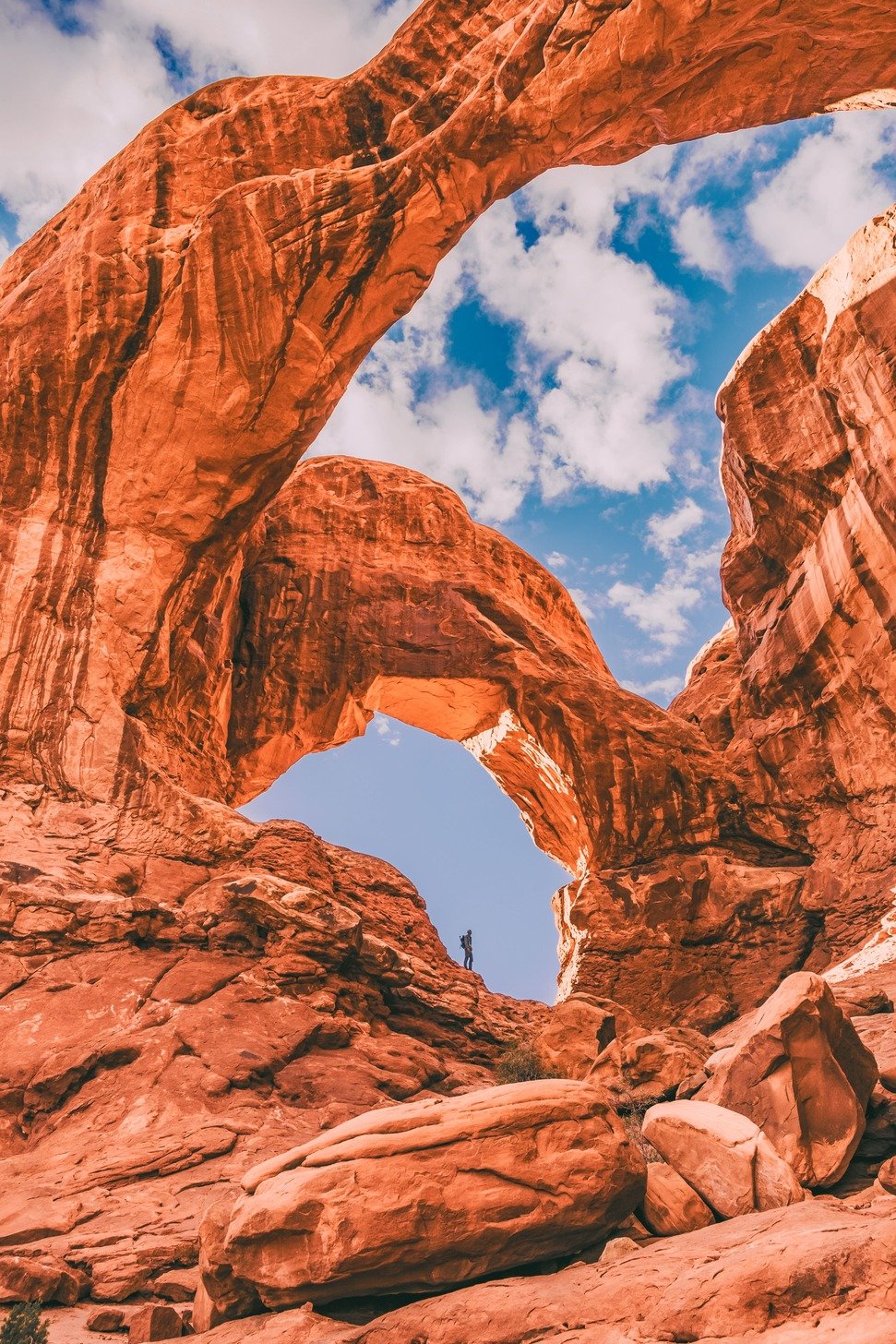 Hiker walking among the sandstone structures of Arches National Park