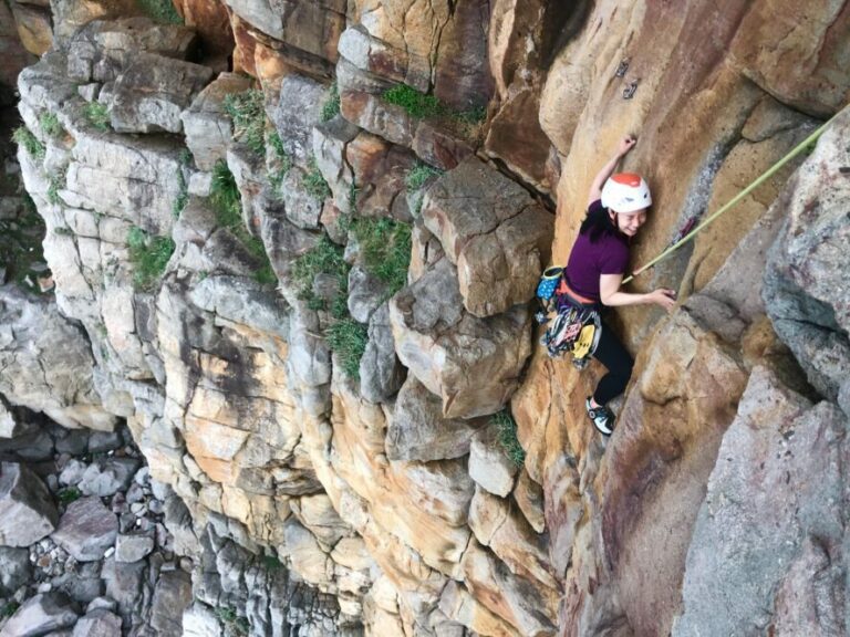 A woman laughing and climbing at Long Dong in Taiwan