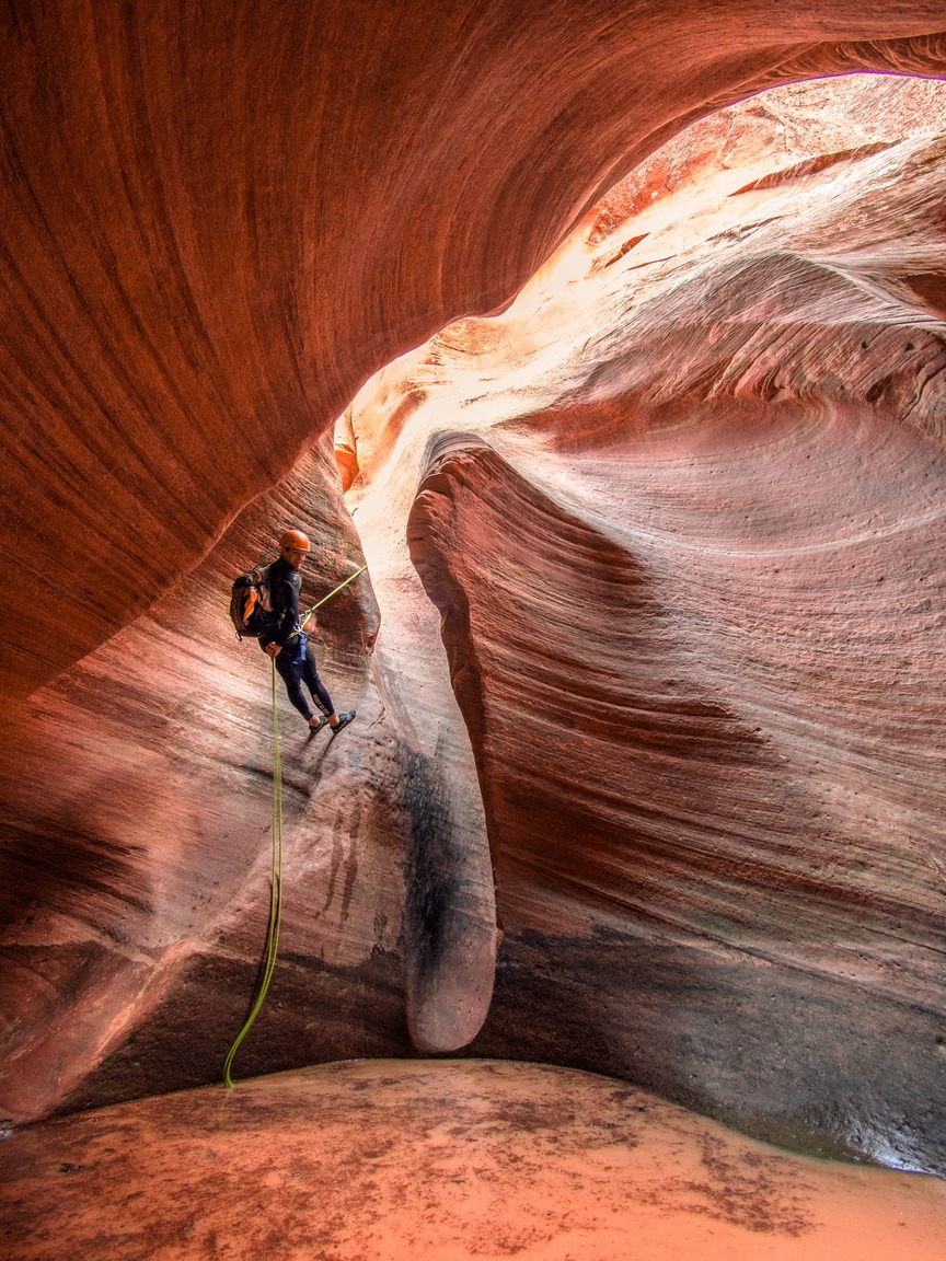 Person rappelling down a slot canyon in Zion National Park