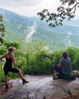 Hikers resting on the rock with an amazing vista over the Appalachian Trail.