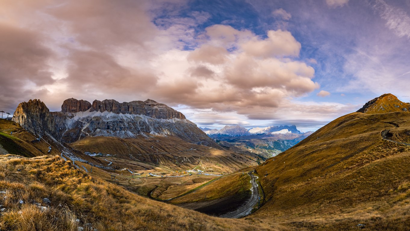 Autumn evening alpine Dolomites mountain scene from hiking path betwen Pordoi Pass and Fedaia Lake, Trentino, Italy. Snowy Marmolada massif and Glacier in far right.