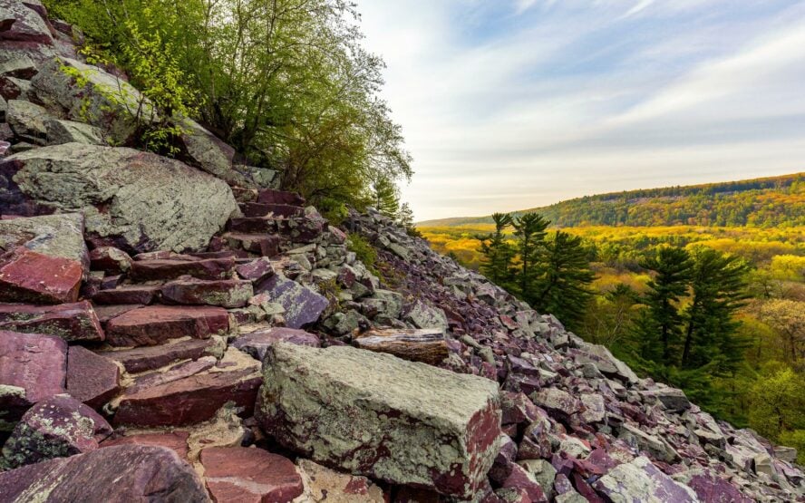 The purple quartzite rock of Devil’s Lake State Park stands out in the light of a fall evening.