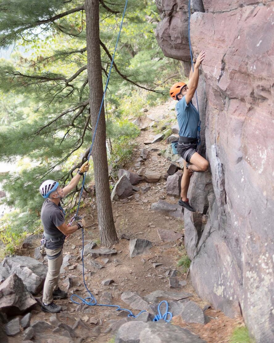 Belayer secures climber on top rope as they climb in the section of East Rampart.