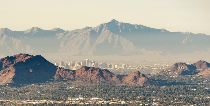 The Phoenix skyline showing the McDowell Mountains and Camelback Mountain through smog.