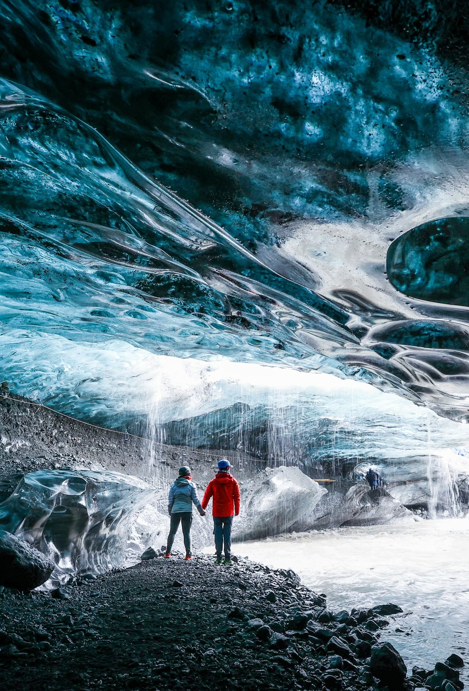 A couple stading in an ice cave, surrounded by eternal ice and snow