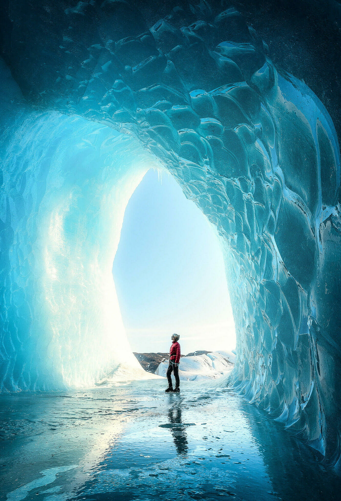 A person stading in a big ice cave in Iceland full of blue light