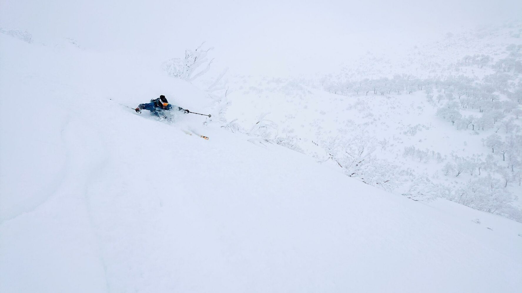 A skier skiing down a slope in Hokkaido, Japan.
