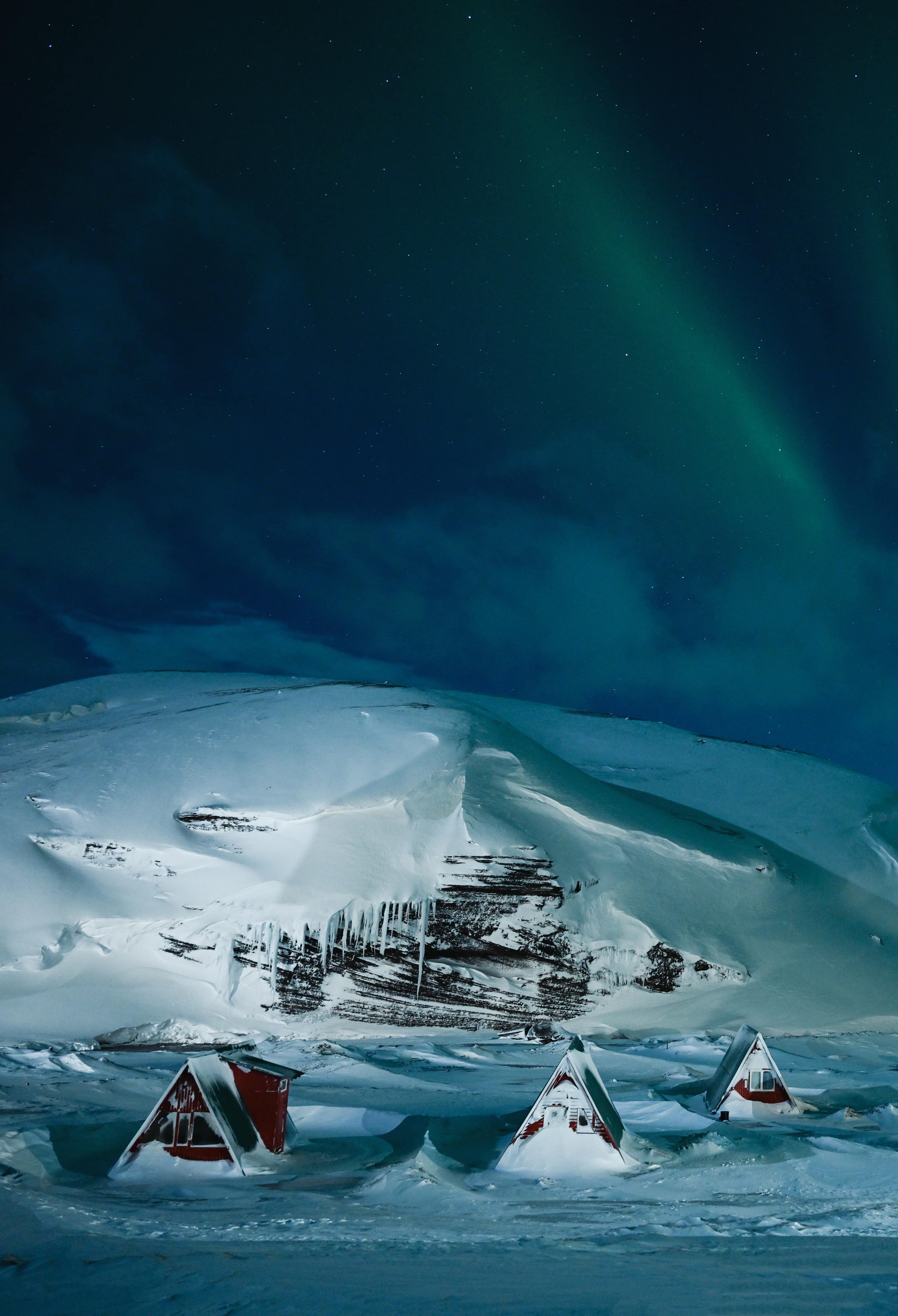 A small snow-covered Icelandic village with aurora borealis above