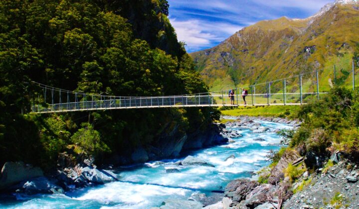 Hikers crossing swing bridge over Matukituki river
