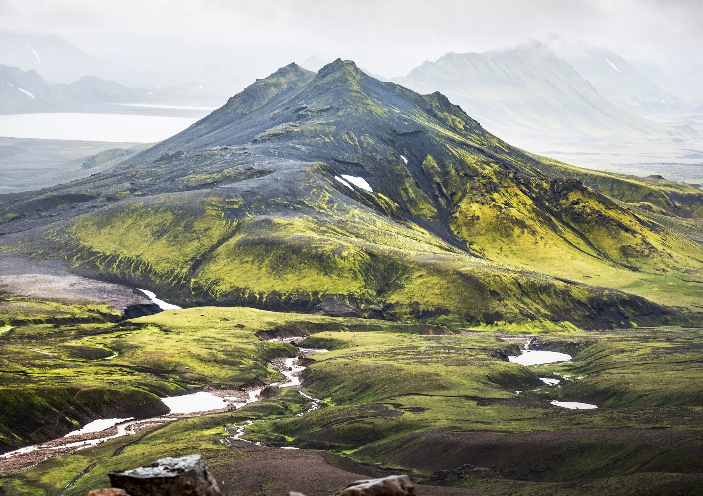 Iceland's landscape is dotted with green mountains and volcanoes