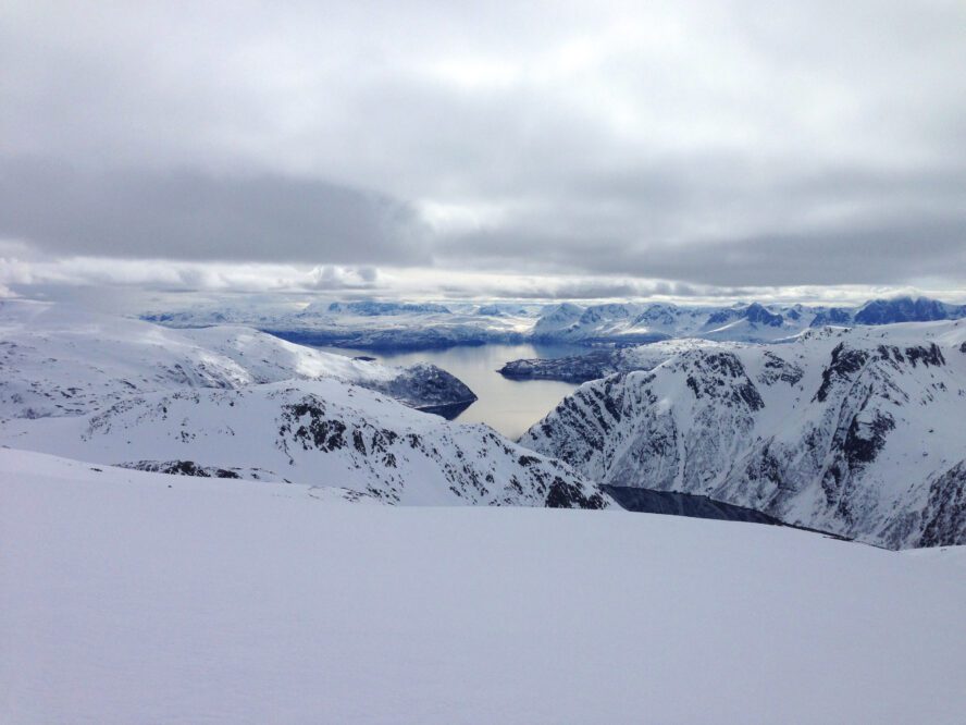 The stark contrast of snow and sea creates a unique dream landscape for the adventurous backcountry skier.