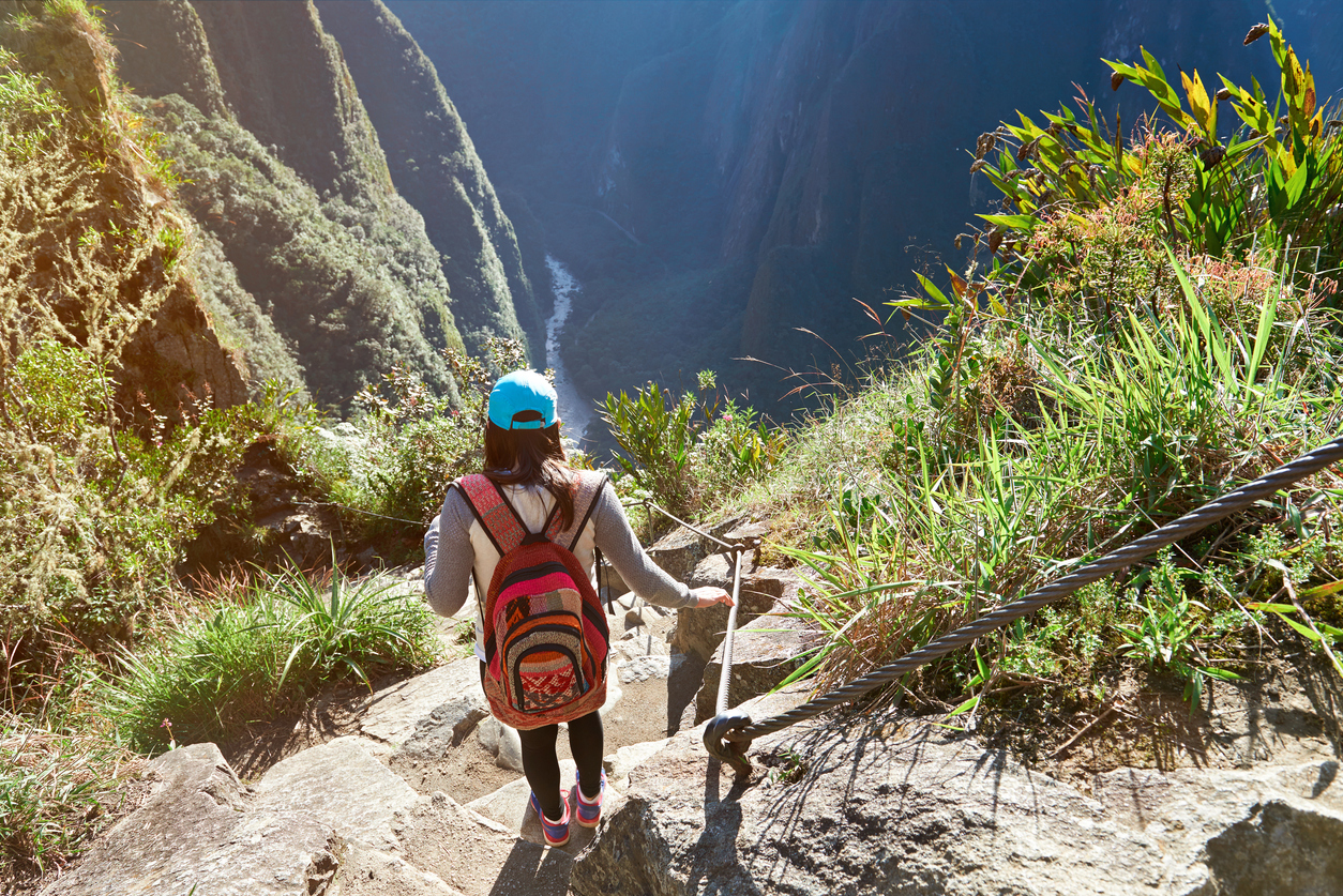 Woman in nature adventure walk in mountain landscape. Girl doing trekking in Machu Picchu path
