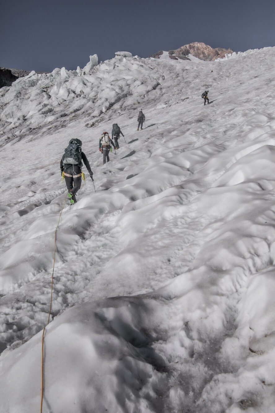 A team of mountaineers ropes up as they climb the glaciated north side of Mount Shasta.