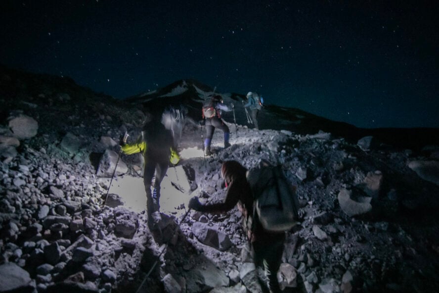 A group of mountain climbers push towards the summit of Mount Shasta in the early dawn.