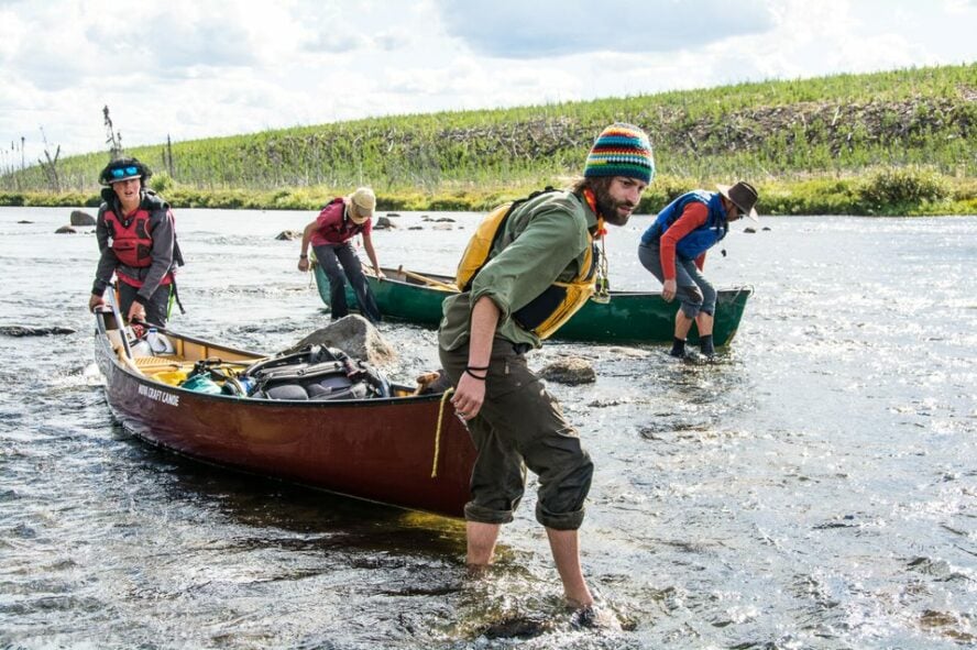 Canoers dragging canoes in the Hawkrock River, Canada 