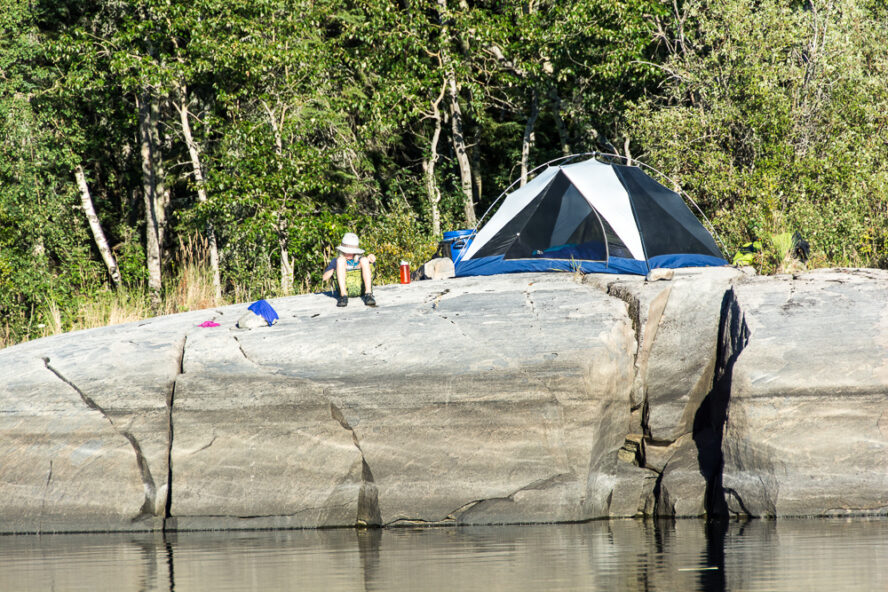 A man relaxing at a campsite next to a river in Canada