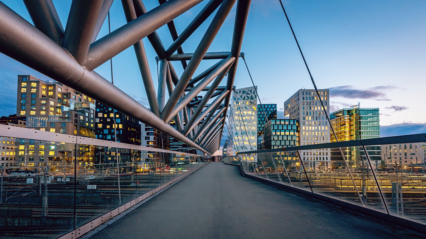 A view of Oslo’s office buildings from a steel bridge. The path on the bridge leads the eye to the view of city buildings. 