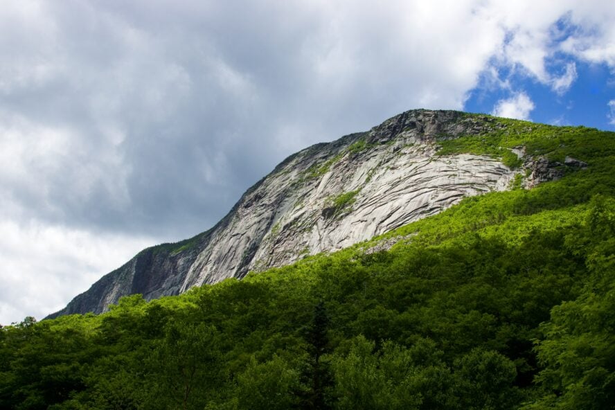 Cannon Mountain in the White Mountains of New Hampshire, rising from a lush forest below.