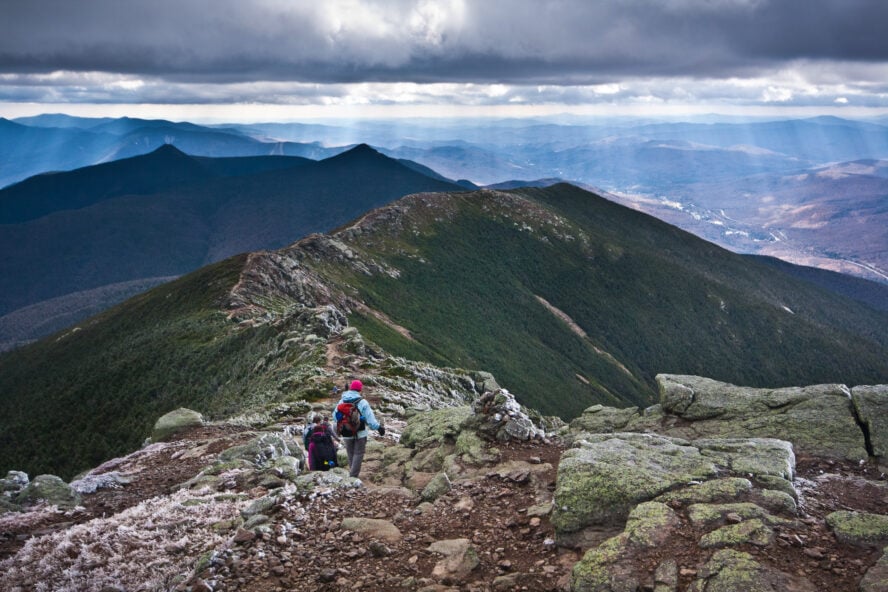 A group of hikers working along the stony spine of the Franconia Ridge hike in New Hampshire.