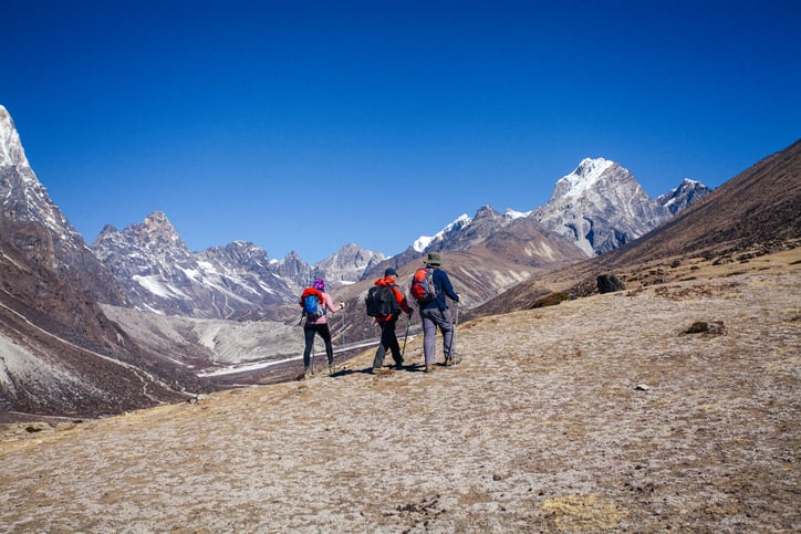 Group of three hikers and adventurers walking over Himalayas