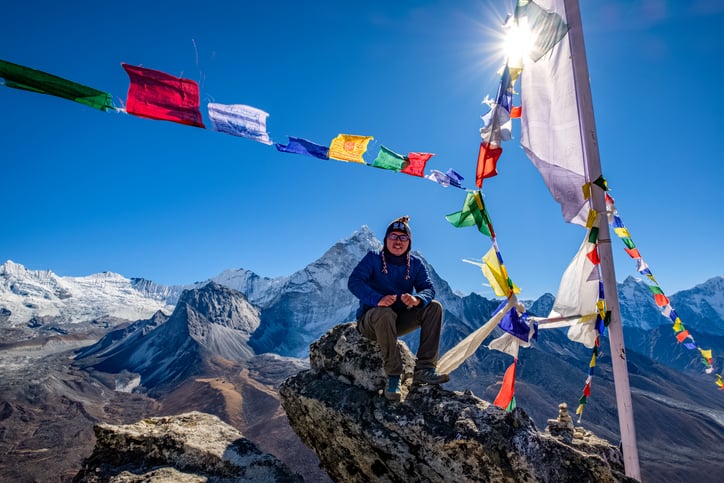 A hiker sitting on the cliff in Nangkartsang Peak