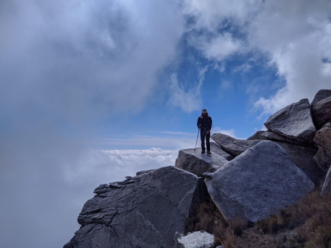 Hiker standing above the clouds.