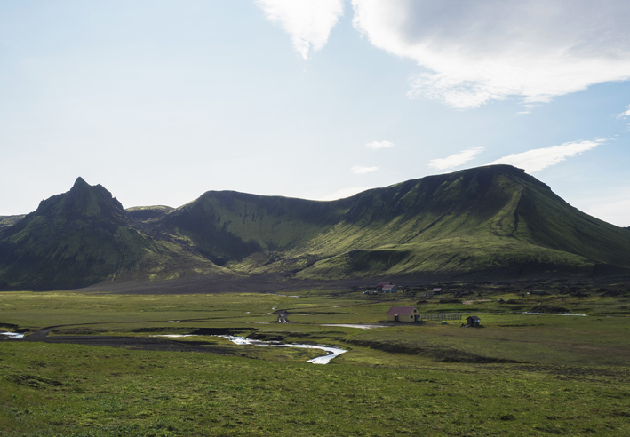 view on Hvanngil mountain hut and camp site with green hills, river stream and lush grass and moss. Laugavegur hiking trail, Fjallabak Nature Reserve