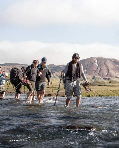 Hikers traversing the river crossing in Iceland.