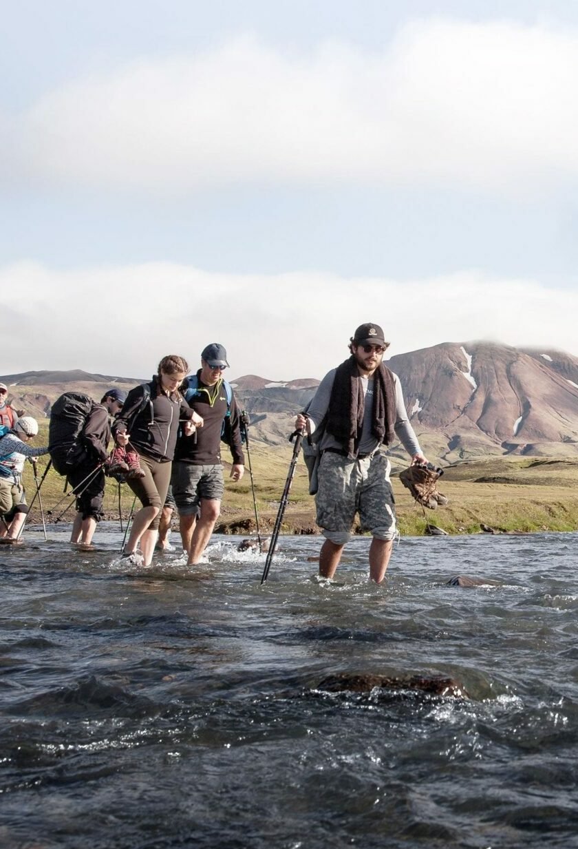 Hikers traversing the river crossing in Iceland.