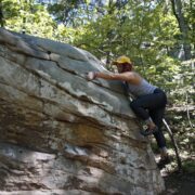 A climber warms up on slopey boulders at Stone Fort.