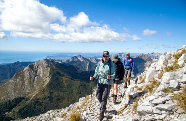 Group of hikers walking along a ridge of the Apuan Alps in Tuscany.