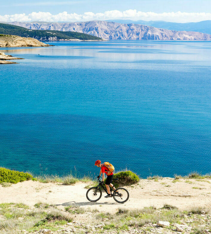 Cyclist riding above the blue Adriatic Sea