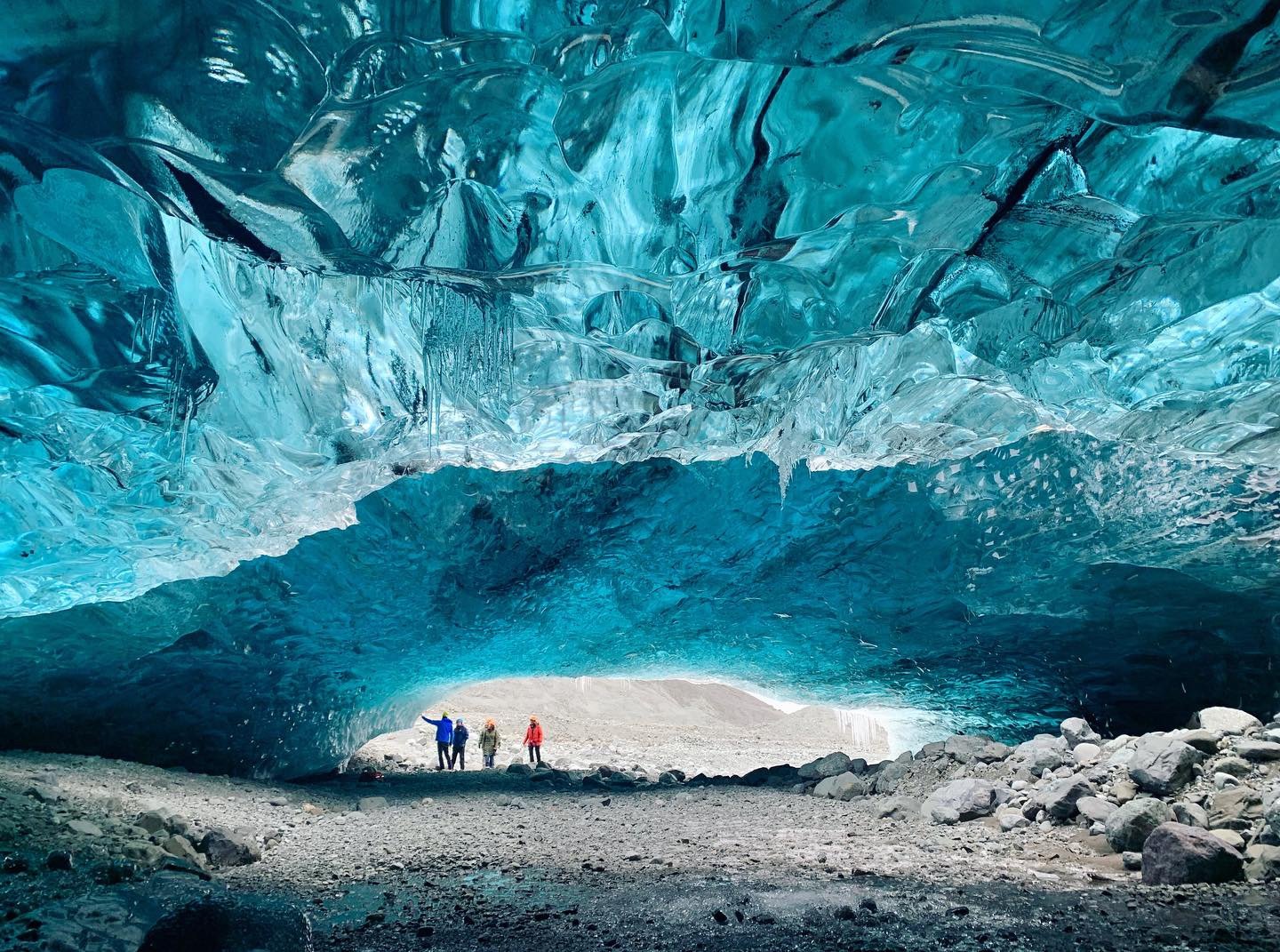 People walking underneath ice in an icecave