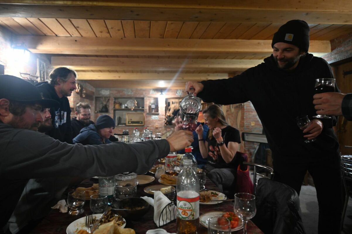 Skiers eating, drinking, and relaxing in a family-owned lodge in Oni, Georgia.