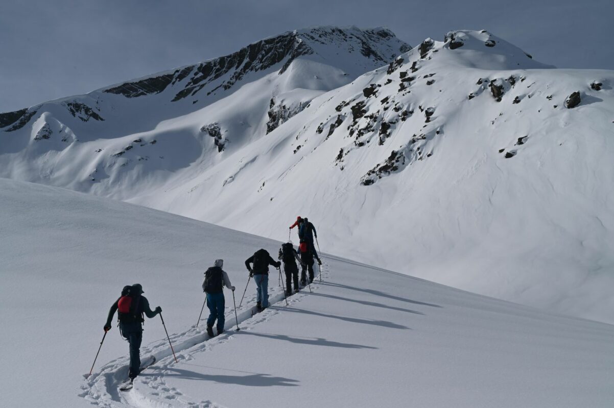 A group of skiers traversing along the mountains near Racha, Georgia.